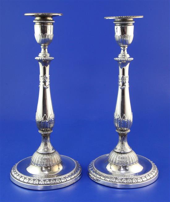 A pair of George III silver candlesticks by John Winter & Co, weighted.